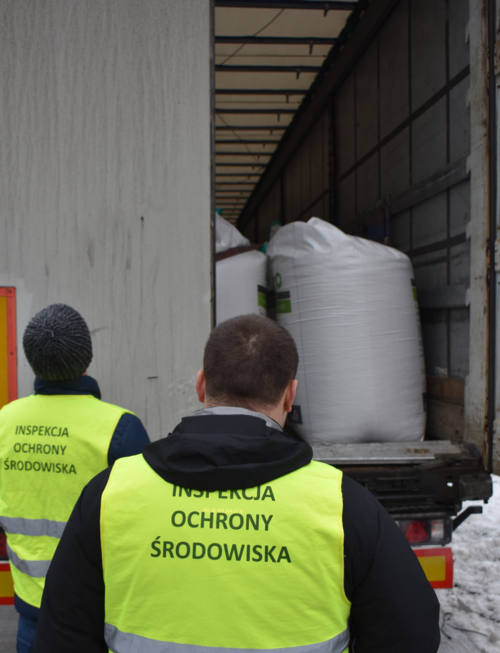Inspektor Wojewódzkiego Inspektoratu Ochrony Środowiska w Warszawie kontroluje zawartość naczepy samochodu ciężarowego.
