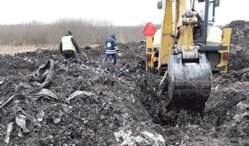 Inspektor Wojewódzkiego Inspektoratu Ochrony Środowiska w Warszawie prowadzi oględziny w miejscu nielegalnie zgromadzonych odpadów.